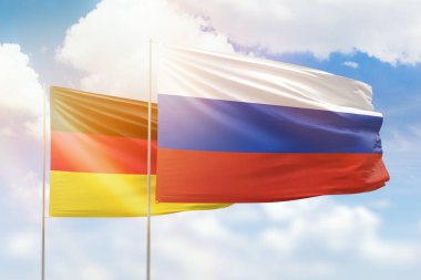 Sunny blue sky and flags of russia and germany