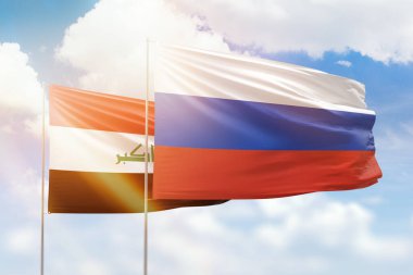 Sunny blue sky and flags of russia and iraq