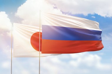 Sunny blue sky and flags of russia and japan