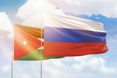 Sunny blue sky and flags of russia and jordan