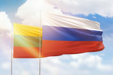Sunny blue sky and flags of russia and lithuania