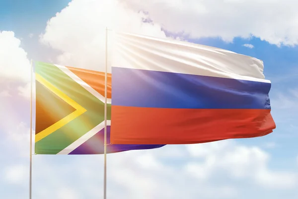 Sunny blue sky and flags of russia and south africa