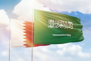Sunny blue sky and flags of saudi arabia and qatar