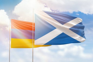 Sunny blue sky and flags of scotland and armenia