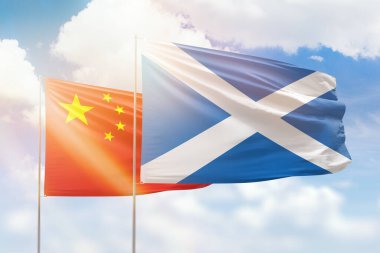 Sunny blue sky and flags of scotland and china