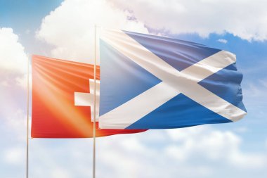 Sunny blue sky and flags of scotland and switzerland