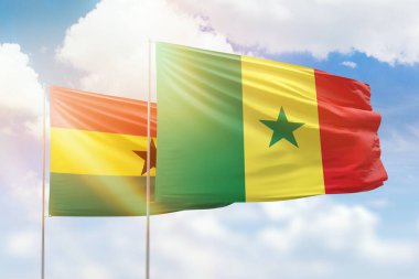 Sunny blue sky and flags of senegal and ghana