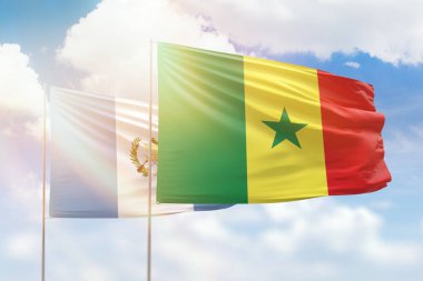 Sunny blue sky and flags of senegal and guatemala