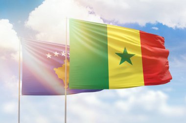Sunny blue sky and flags of senegal and kosovo