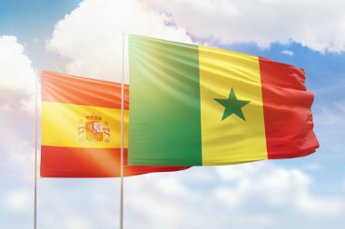 Sunny blue sky and flags of senegal and spain