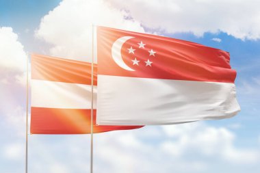 Sunny blue sky and flags of singapore and austria