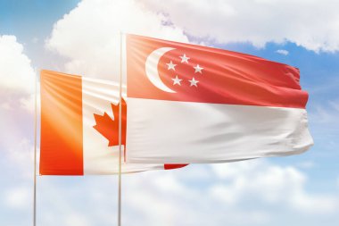 Sunny blue sky and flags of singapore and canada