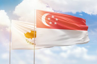 Sunny blue sky and flags of singapore and cyprus