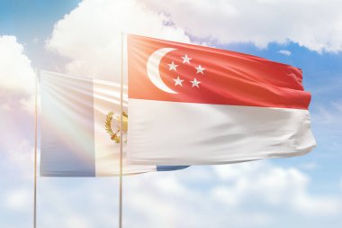 Sunny blue sky and flags of singapore and guatemala