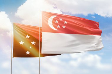 Sunny blue sky and flags of singapore and papua new guinea