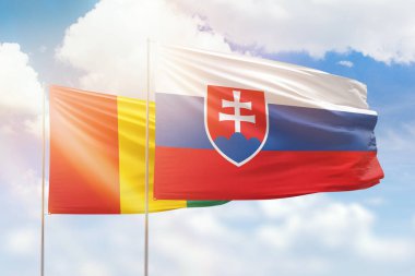Sunny blue sky and flags of slovakia and guinea