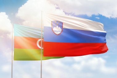 Sunny blue sky and flags of slovenia and azerbaijan