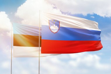 Sunny blue sky and flags of slovenia and estonia
