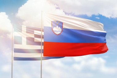 Sunny blue sky and flags of slovenia and greece