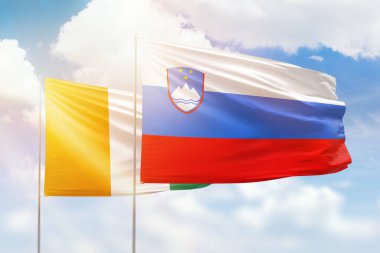 Sunny blue sky and flags of slovenia and ivory coast