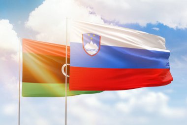 Sunny blue sky and flags of slovenia and libya