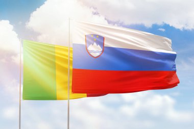 Sunny blue sky and flags of slovenia and mali