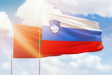 Sunny blue sky and flags of slovenia and morocco