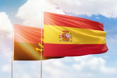 Sunny blue sky and flags of spain and angola