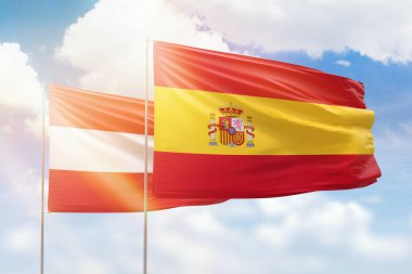 Sunny blue sky and flags of spain and austria