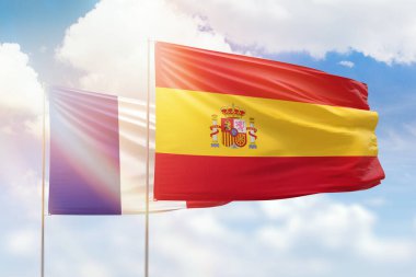 Sunny blue sky and flags of spain and france