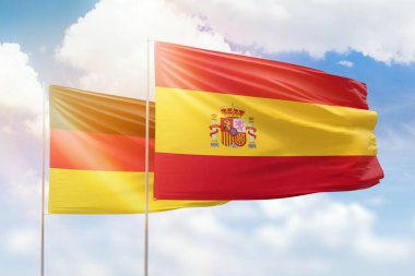 Sunny blue sky and flags of spain and germany