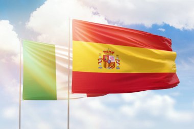 Sunny blue sky and flags of spain and italy