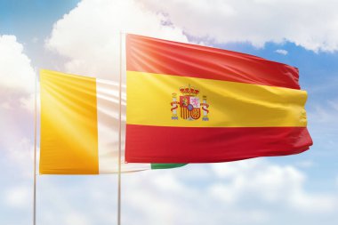 Sunny blue sky and flags of spain and ivory coast