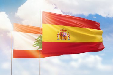 Sunny blue sky and flags of spain and lebanon