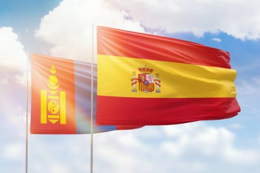Sunny blue sky and flags of spain and mongolia