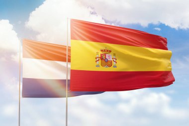 Sunny blue sky and flags of spain and netherlands