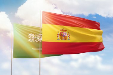 Sunny blue sky and flags of spain and saudi arabia
