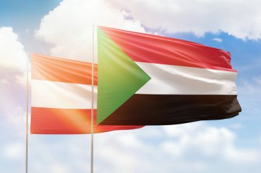Sunny blue sky and flags of sudan and austria