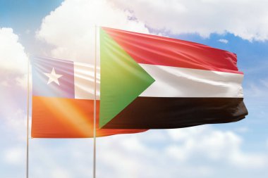 Sunny blue sky and flags of sudan and chile