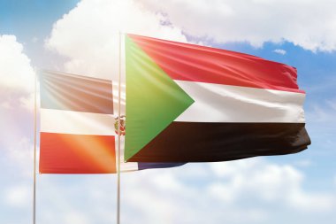 Sunny blue sky and flags of sudan and dominican republic