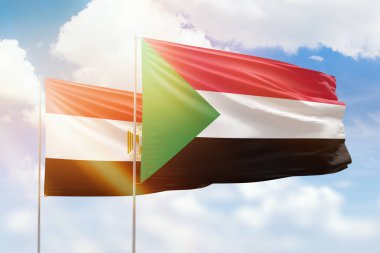 Sunny blue sky and flags of sudan and egypt