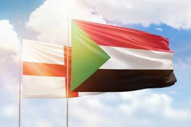 Sunny blue sky and flags of sudan and england