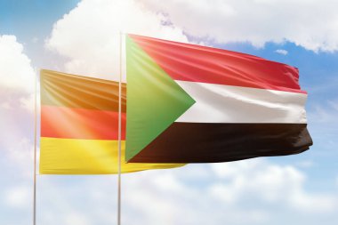Sunny blue sky and flags of sudan and germany