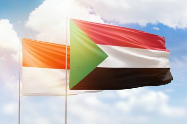 Sunny blue sky and flags of sudan and indonesia