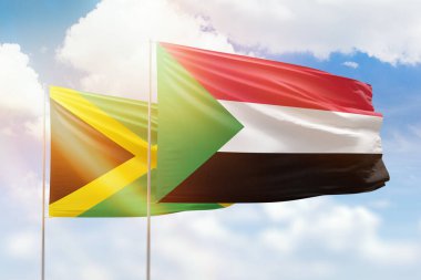 Sunny blue sky and flags of sudan and jamaica