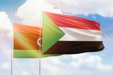 Sunny blue sky and flags of sudan and libya
