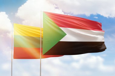 Sunny blue sky and flags of sudan and lithuania