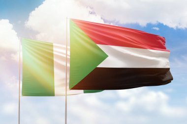 Sunny blue sky and flags of sudan and nigeria
