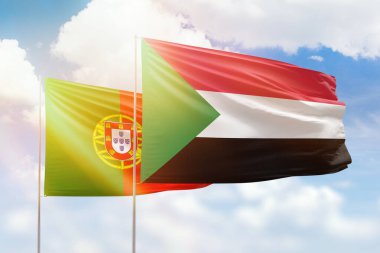 Sunny blue sky and flags of sudan and portugal