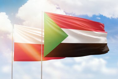 Sunny blue sky and flags of sudan and poland